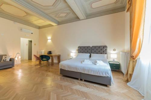 a bedroom with a large bed and a wooden floor at Aldrovandi Luxury Suites and Apartment in Bologna