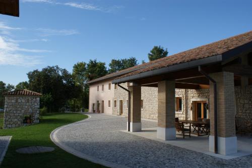 a stone building with a pavilion next to a road at Country House Due Fiumi in Sacile