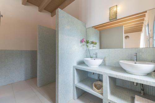 La salle de bains est pourvue de 2 lavabos et d'un miroir. dans l'établissement Casa Colonial Sitges Hills, à Olivella