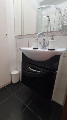 a bathroom with a white sink and a mirror at Apartament Przy Starówce - Bella in Bolesławiec