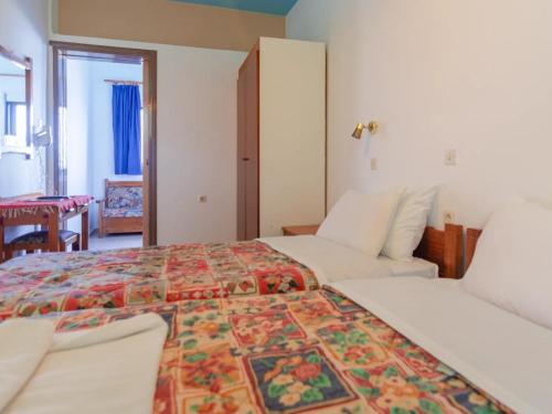 ein Schlafzimmer mit einem großen Bett mit einer farbenfrohen Tagesdecke in der Unterkunft Haris Studios in Palaiochóra