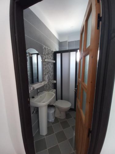 ein Badezimmer mit einem Waschbecken, einem WC und einem Spiegel in der Unterkunft La bananeraie in Tamri