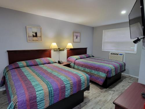 Una cama o camas en una habitación de Knights Inn Cobourg