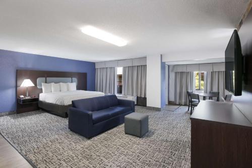 a hotel room with a bed and a couch and a chair at SureStay Plus Hotel by Best Western Gatlinburg in Gatlinburg