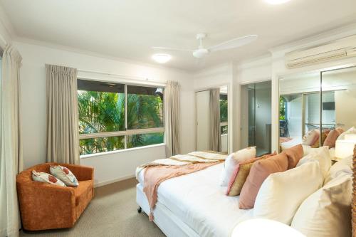 a bedroom with a bed and a large window at Lantana Lakes - Resort Style Living in Cairns North