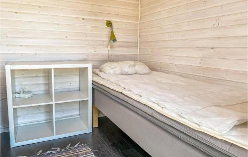 a bed in a wooden room with a shelf at 5 Bedroom Stunning Home In Mellbystrand in Mellbystrand