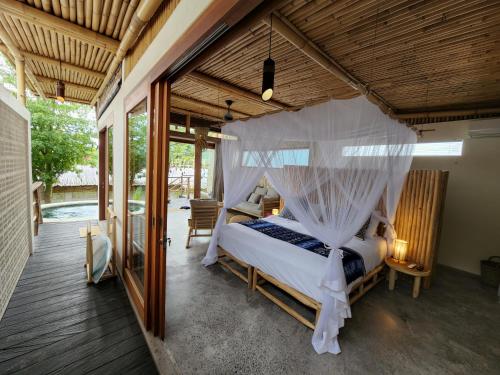 Jellyfish Villas Bingin Beach في أُلُواتو: غرفة نوم مع سرير مظلة في منزل