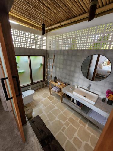 uma casa de banho com um lavatório e um espelho em Jellyfish Villas Bingin Beach em Uluwatu