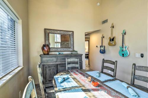 a dining room with a table and a mirror and guitars on the wall at Mountain-View Deck Bright Sedona Home in Sedona