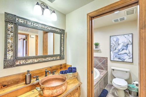 a bathroom with a sink and a toilet and a mirror at Mountain-View Deck Bright Sedona Home in Sedona