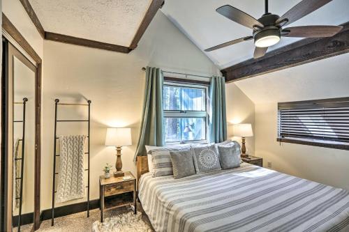 1 dormitorio con 1 cama, ventilador de techo y ventana en Woodsy Flagstaff Hideaway with Deck and Sunroom!, en Mountainaire
