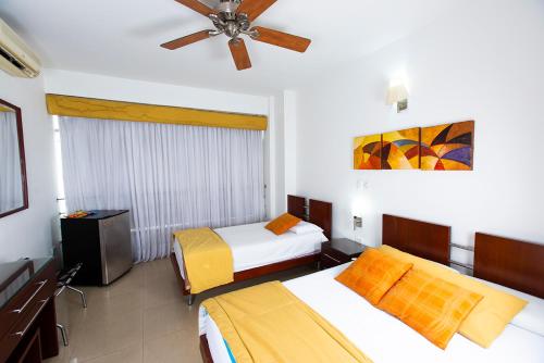 ククタにあるAtlantis Plaza Hotel Cúcutaのベッド2台、天井ファンが備わる客室です。