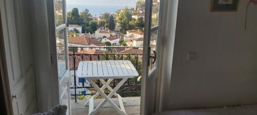 a white stool sitting on a balcony with a view at Tsitsinakis Traditional House in Hydra