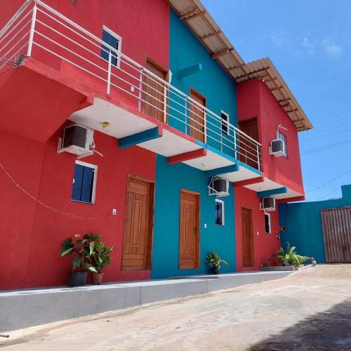 a red and blue building with a staircase at Pousada BG Lençóis in Barreirinhas