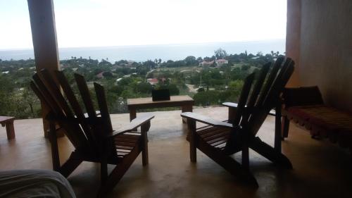 two chairs and a table in a room with a view at Welcoming vibes in Treasure Beach