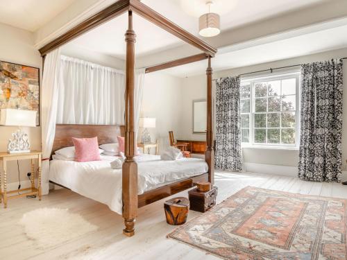 a bedroom with a canopy bed and a rug at Hilltop House in Tenbury