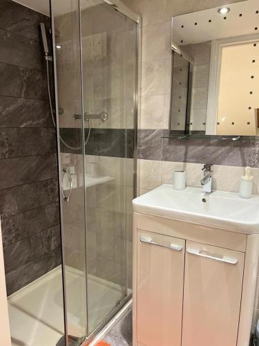 a bathroom with a shower and a sink and a mirror at 93 West Road in Stratford