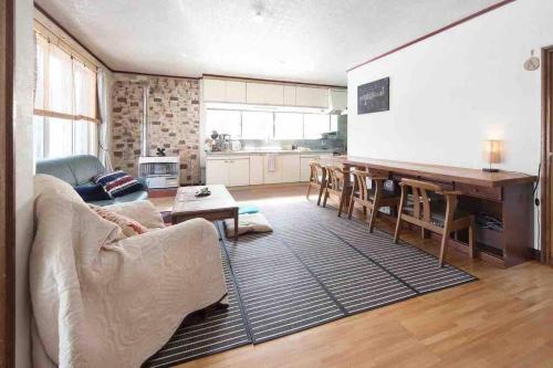 uma sala de estar com um sofá e uma mesa em Vacation House ROMAN em Noboribetsu