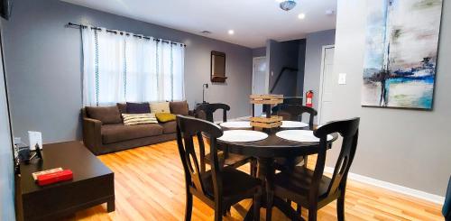 sala de estar con mesa y sofá en GREAT 2 bedroom Condo,FREE parking,easy commute. en Irvington