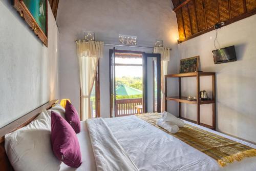 a bedroom with a bed and a large window at The Mountain Cottage in Nusa Penida