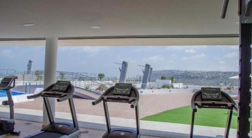 een rij cardio-apparaten in een sportschool met uitzicht op een honkbalveld bij Infinity View SNB in Arenales del Sol