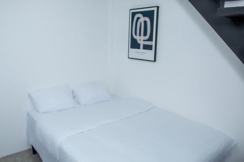 a white bed with a sign on the side of it at The Stay Inn in San José