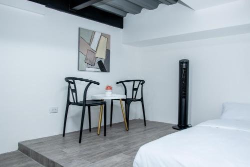 two chairs and a table in a room with a bed at The Stay Inn in San José