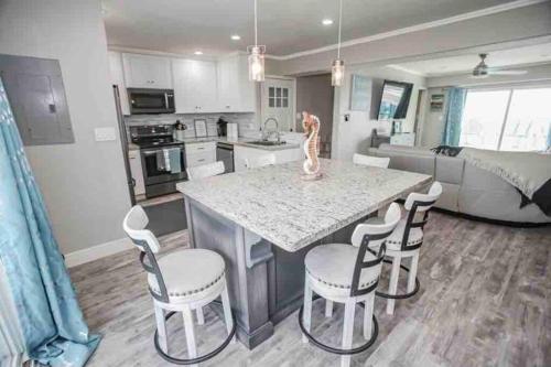 a kitchen with a island with chairs and a counter top at Beachfront Retreat FREE use of GOLF CART in Surfside Beach