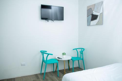 a room with two chairs and a table and a tv at The Stay Inn in San José