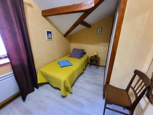 a small bedroom with a yellow bed in a room at Gîte Le Val-d'Ajol, 2 pièces, 4 personnes - FR-1-589-194 in Le Val-dʼAjol