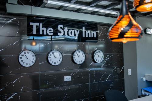 a group of clocks on a wall with the stay inn at The Stay Inn in San José