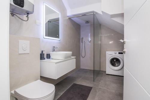 y baño con lavamanos y lavadora. en Apartments with a parking space Vir - 20013, en Vir