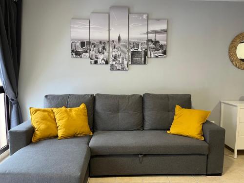 un divano grigio con cuscini gialli in soggiorno di Donde AbueLía a Santa Cruz de la Palma