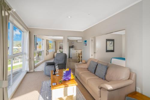 a living room with a couch and two chairs at Waterfront Apartments Whitianga in Whitianga