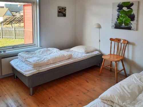 a bedroom with a bed and a chair and a window at 6 person holiday home in Hadsund-By Traum in Hadsund