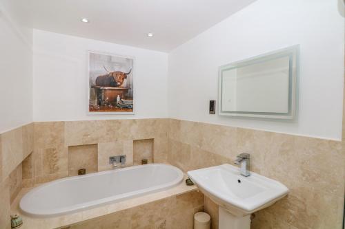 a bathroom with a bath tub and a sink at Lake View in Crediton