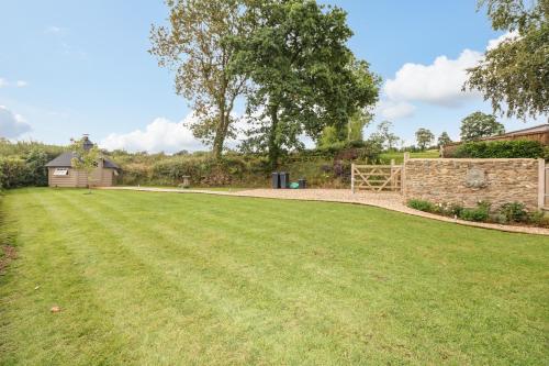 a large grassy yard with a barn in the background at Lake View in Crediton
