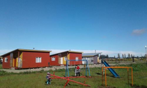 Twee kinderen spelen op een speelplaats voor huizen. bij Cabañas Juan José in Castro