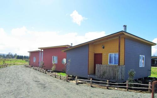 een rij kleine huisjes aan een onverharde weg bij Cabañas Juan José in Castro