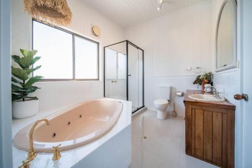 un bagno con vasca, lavandino e WC di Salt Bush Beach House~the ultimate Fleurieu escape a Aldinga Beach
