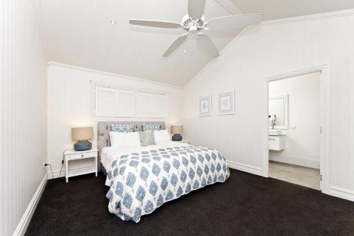 a bedroom with a bed and a ceiling fan at The Hamptons Beach House near Dutchie's walk to Nelson Bay in Nelson Bay