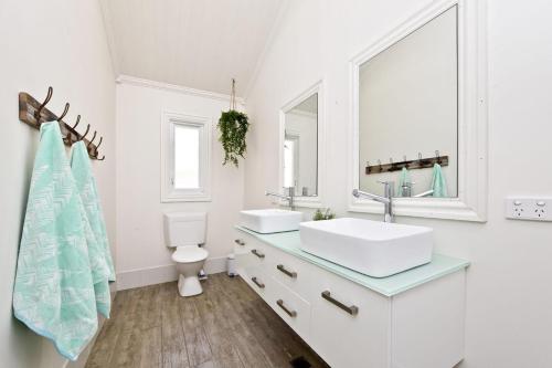 La salle de bains blanche est pourvue de 2 lavabos et de toilettes. dans l'établissement The Hamptons Beach House near Dutchie's walk to Nelson Bay, à Nelson Bay
