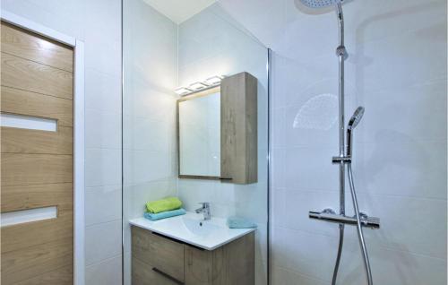 La salle de bains blanche est pourvue d'un lavabo et d'une douche. dans l'établissement Amazing Apartment In St Romans With Kitchenette, 