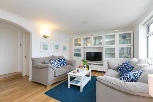 a living room with two couches and a tv at Atlantic Waves in Carbis Bay