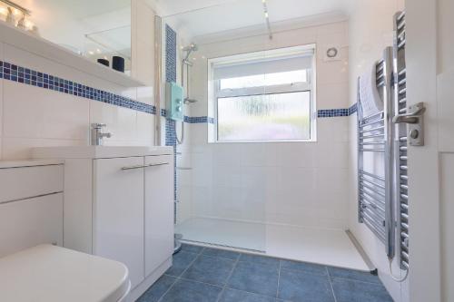 a bathroom with a shower and a toilet and a window at Atlantic Waves in Carbis Bay