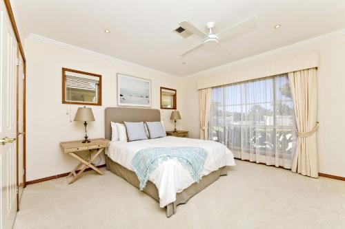 a bedroom with a bed and a large window at One Mile Mansion - Private Coastal Retreat in One Mile