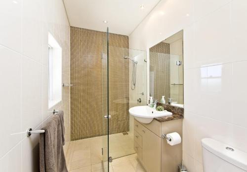 a bathroom with a glass shower and a sink at Harbour View Penthouse - The Perfect Location in Nelson Bay
