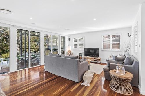 a living room with two couches and a television at Driftwood in Soldiers Point