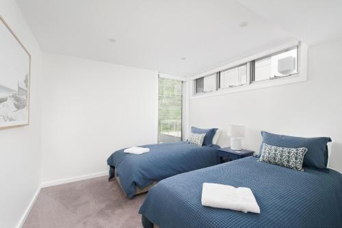 1 dormitorio con 2 camas y ventana en Baydream on the Beach - With Breathtaking Water Views, en Corlette