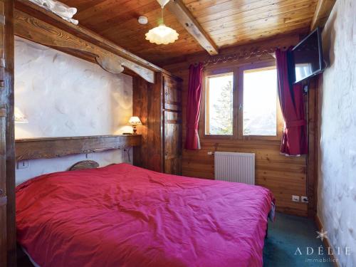 sypialnia z czerwonym łóżkiem w drewnianym pokoju w obiekcie Appartement Montvalezan-La Rosière, 2 pièces, 5 personnes - FR-1-398-649 w mieście Montvalezan